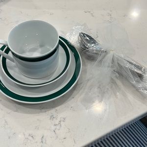 Tea set includes plate, saucer and cup with spoon. White with green edge